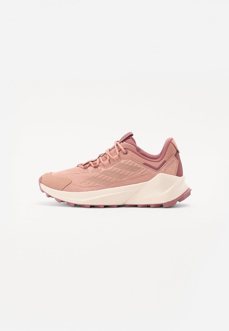 Pink athletic shoe with a textured mesh upper, rubber sole, and cushioned heel. Features contrasting shades and a streamlined design.