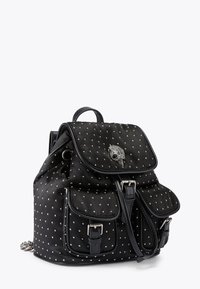 Czarny plecak z srebrnymi ćwiekami, dwoma przednimi kieszeniami z klamrami, zapięciem na klapę z ozdobnym emblematem ptaka oraz górnym uchwytem.