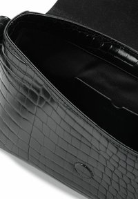 Borsa in pelle nera con stampa a croco, dotata di chiusura a linguetta magnetica, che mostra l'interno foderato in tessuto nero.