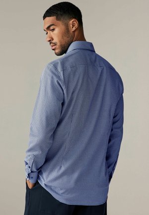Blue checkered button-up shirt with a spread collar, textured fabric, and long sleeves. Features adjustable cuffs and a relaxed fit.