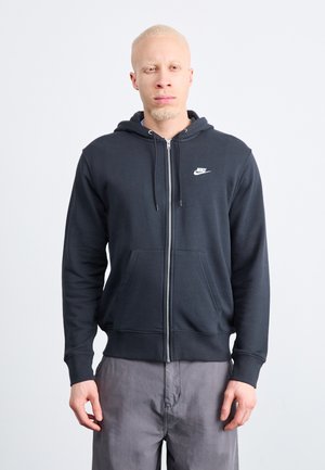 Nike zip-up hoodie in dark gray, made of soft fabric, featuring a front pocket, drawstring hood, and white logo on the left chest.