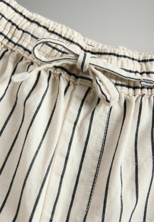 Lightweight cotton shorts in a cream color with thin black stripes, featuring an elastic waistband and tie detail at the front.