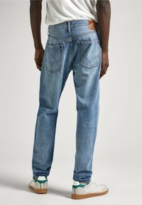 Ljust blå denimjeans med avslappnad passform, bakfickor med sömdetaljer och en märkesläderlapp på midjebandet.