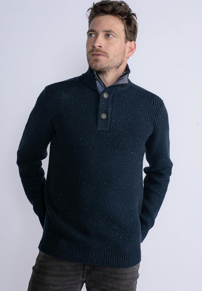 Pulover tricotat bleumarin cu guler cu nasturi, mansete și tiv cu dungi; prezintă un model texturat cu nuanțe subtile pe întreaga suprafață.