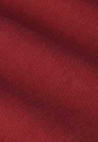 Tissu rouge côtelé avec une surface texturée, présentant un motif uniforme de nervures verticales et un léger éclat.