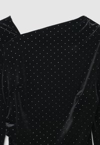 Schwarzes Samtkleid mit glatter Textur, verziert mit gleichmäßig verteilten silbernen Polka-Dots auf dem Stoff.