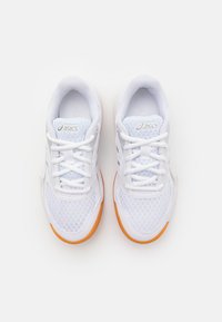 White athletic shoes with mesh upper, lace closure, and rubber outsole. Features orange accents on the sole; minimal design elements.