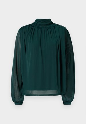 Πράσινο μπλουζάκι με ψηλό λαιμό, μακριά ημιδιάφανα μανίκια, πιέτες μπροστά και άνετη γραμμή. Φτιαγμένο από ελαφρύ ύφασμα για μία ρέουσα εμφάνιση.