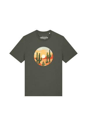 Donkergroen T-shirt met een cirkelvormig woestijndesign met cactussen en een ondergaande zon tegen een oranje lucht.
