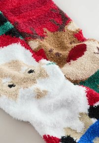 Pūkuotas brīvdienu zeķes ar Ziemassvētku vecīša un ziemeļbriežu dizainiem. Krāsas ietver sarkanu, zaļu, balta un brūna ar teksturētu apdari.
