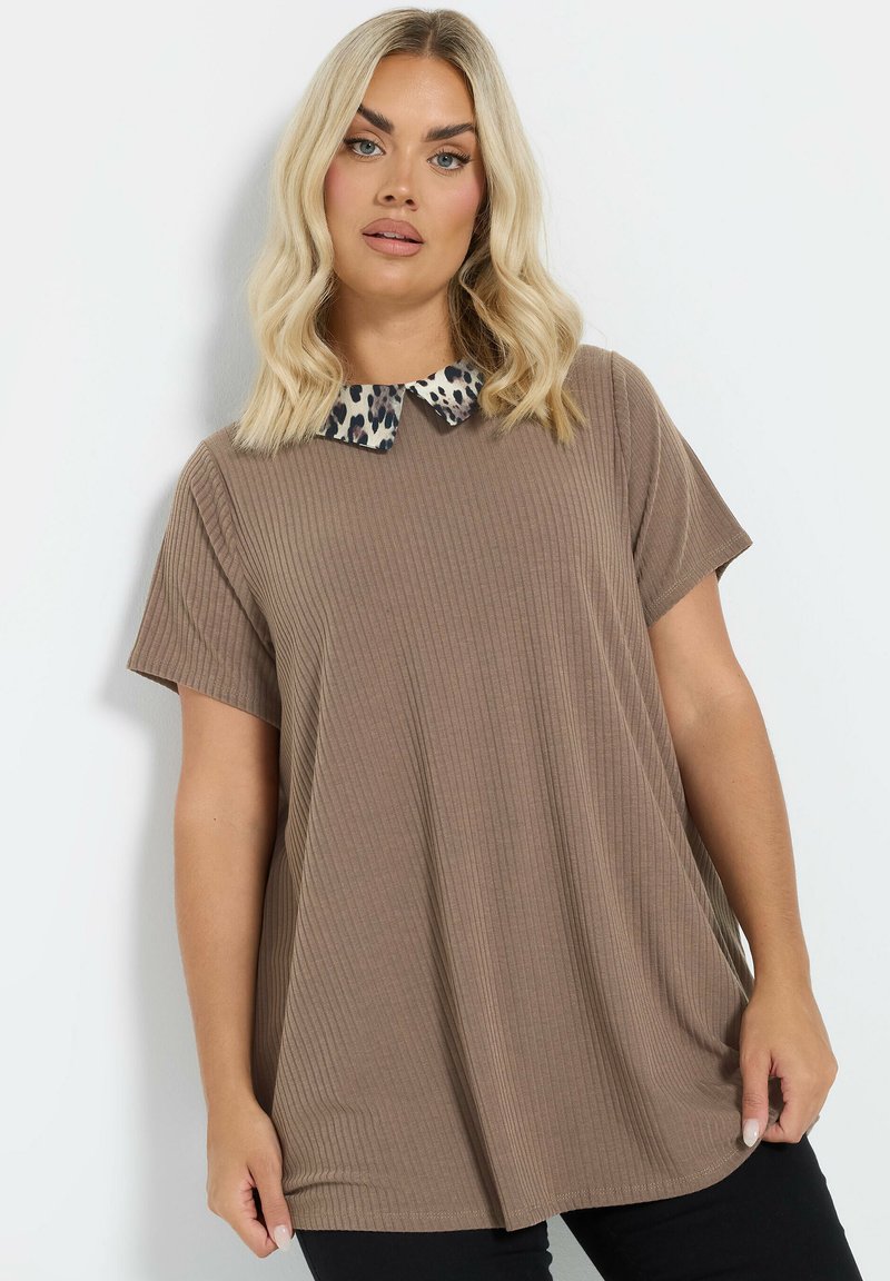 T-shirt oversize marrone a coste con maniche corte e collo con stampa leopardata. Texture liscia, vestibilità comoda e orlo arrotondato.