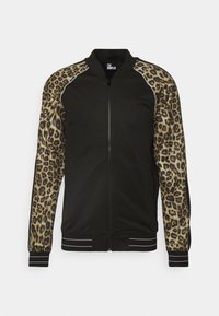 Giacca bomber nera con maniche a stampa leopardata, polsini e orlo a righe a costine, e chiusura con zip. Realizzata in tessuto comodo.