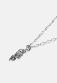 Hõbedast kaelakee, millel on kettide disain ja keskne ripats, mis kannab sõnu "Surm enne häbistamist" vöödisainis.