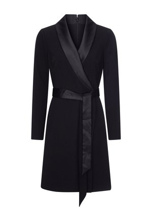 Zwarte wikkeljurk met lange mouwen, satijnen revers en riem. De stof lijkt glad met een gestructureerde vorm en een ritsluiting aan de achterkant.