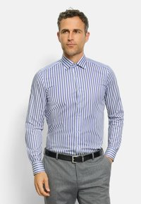 Gestreifte Hemdbluse in Hellblau und Weiß, mit langen Ärmeln, aus Baumwolle, taillierter Schnitt, kombiniert mit grauen Hosen und einem schwarzen Gürtel.