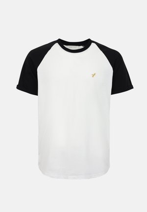 T-shirt blanc à manches courtes avec manches raglan noires, col rond noir et petit logo d'oiseau jaune sur la poitrine gauche.