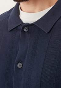 Marine gebreide shirt met een kraag, featuring textuurstrips en twee knopen. Gemaakt van stof met een gladde afwerking.