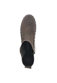 Bottine en suède marron avec un bout arrondi, des panneaux élastiques sur les côtés et une semelle en caoutchouc texturée. Logo Gabor visible sur la semelle intérieure rembourrée.
