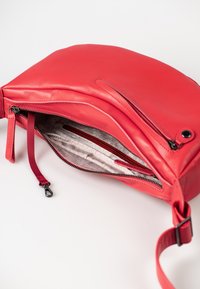 Rote Lederschultertasche mit glatter Struktur, Reißverschlussverschluss und einem geräumigen Innenraum, der mit einem hellen Stofffutter und Innentaschen ausgestattet ist.