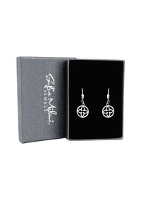 Silverörhängen med cirkulär design och blommotiv, visade i en grå texturerad smyckeslåda med svart sammetinredning.