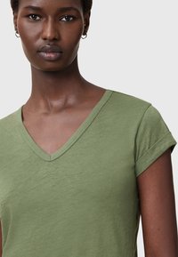 Olivengrøn, kortærmet V-hals T-shirt med opkrøllede ærmer, lavet af blødt stof, der har en afslappet og uformel pasform.