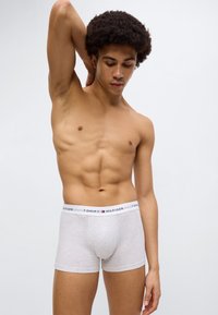 Γκρι βαμβακερά μποξεράκια με λευκή μέση που φέρει το λογότυπο "TOMMY HILFIGER" και μικρό διακοσμητικό λογότυπο. Εφαρμ οστή σχεδίαση, μεσαία μέση.