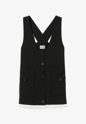 Veste sans manches noire avec un décolleté en V profond, deux poches avant et une fermeture à boutons. Elle présente des bretelles croisées dans le dos et une bordure en dentelle blanche à l'ourlet.