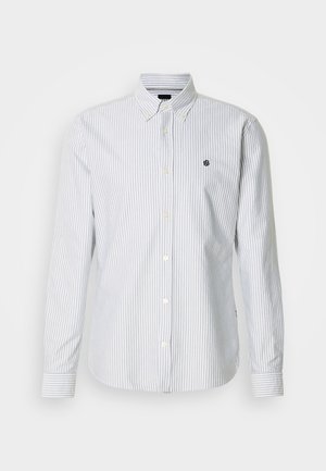 Skjorte med knapper, tynde blå og hvide striber, lange ærmer og en lille logo på brystet, lavet af et letvægtsstof.