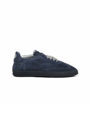 Navyblauwe suède lage sneaker met zwarte zool en grijze veters, zijaanzicht op een witte achtergrond.