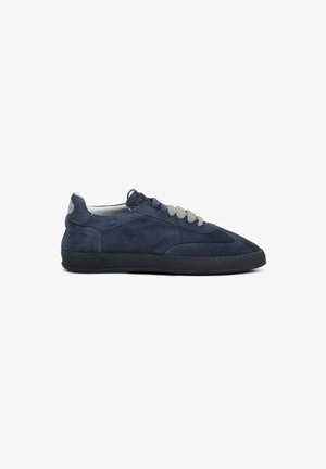 Sneaker low-top in suede blu navy con suola nera e lacci grigi, vista laterale su sfondo bianco.
