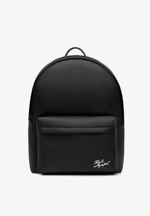 Schwarzer Rucksack mit einer vorderen Reißverschlusstasche, die ein kleines weißes Signaturlogo unten rechts zeigt.