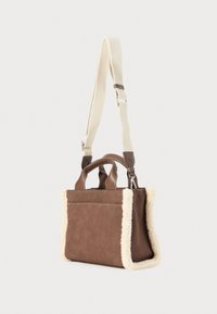 Brown suede handbag with cream fur trim; dual grab handles and adjustable canvas shoulder strap; smooth texture with detailed stitching.