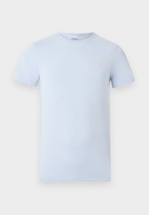Light blue cotton t-shirt with a round neckline, short sleeves, and a small pink embroidered logo on the left chest. Smooth texture.
