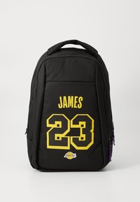 Zwarte rugzak met gele tekst "JAMES 23" en een klein Los Angeles Lakers-logo op het voorvak, voorzien van paarse ritssluitingen.