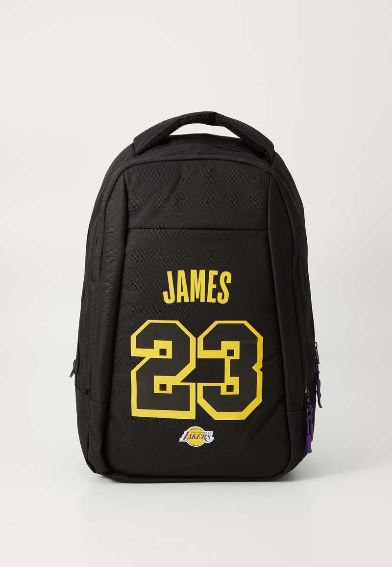 Zwarte rugzak met gele tekst "JAMES 23" en een klein Los Angeles Lakers-logo op het voorvak, voorzien van paarse ritssluitingen.