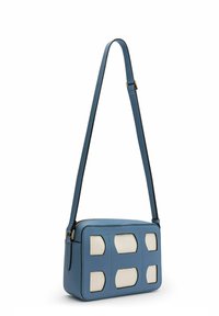 Sac bandoulière en cuir bleu de forme rectangulaire, arborant un motif texturé avec des accents crème et une longue sangle ajustable.