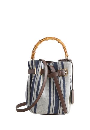 Bucket-Handtasche mit navyblauen und weißen vertikalen Streifen, Bambus-Top-Griff und abnehmbarem braunen Leder-Schulterriemen mit Schnalle.