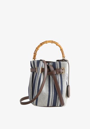 Bucket-Handtasche mit navyblauen und weißen vertikalen Streifen, Bambus-Top-Griff und abnehmbarem braunen Leder-Schulterriemen mit Schnalle.