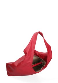 Rode leren totebag met een slouchy vorm, een enkele handgreep en een beige interieur met een ritsvak. Textuur oppervlak.