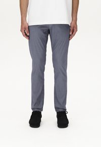 Pantaloni grigi slim-fit realizzati in tessuto testurizzato, con un motivo sottile. Abbinati a scarpe nere con lacci.