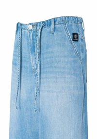 Light blue denim jeans with a relaxed fit, featuring a button closure, drawstring waist, and a branded label near the pocket.