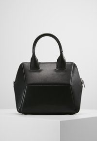 Czarna skórzana torebka o usztywnionej konstrukcji, z dwoma zaokrąglonymi uchwytami i zapięciem na zamek. Płaski spód i kanciaste boki.