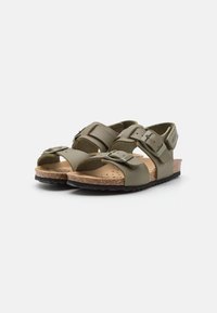 Olivgrön sandaler med justerbara remmar och spännen, korkfotbädd och texturerad svart gummisula. Öppen tådesign.