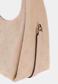 Beige lædertaske med præget blomsterdesign, buet form, en kort rem med guldfarvet hardware og en tekstureret overflade.