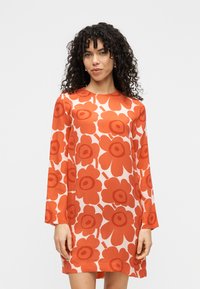 Φόρεμα με μακριά μανίκια, λευκό φόντο με μεγάλα κόκκινα λουλούδια, στρογγυλή λαιμόκοψη και άνετη εφαρμογή από ελαφρύ ύφασμα.