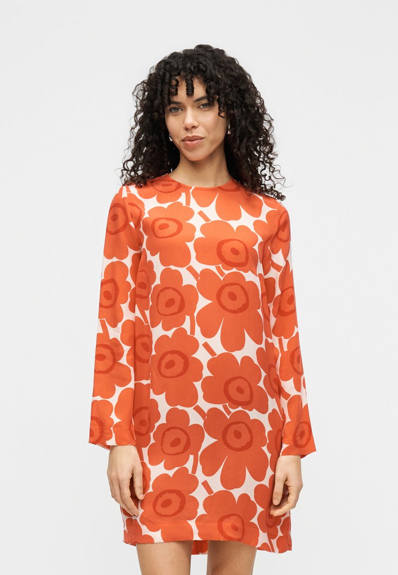 Φόρεμα με μακριά μανίκια, λευκό φόντο με μεγάλα κόκκινα λουλούδια, στρογγυλή λαιμόκοψη και άνετη εφαρμογή από ελαφρύ ύφασμα.