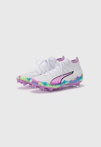 White soccer cleats with a textured upper, featuring a multicolored abstract pattern in pink, blue, and green. Black logo on the side.