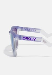 Slníčka s fialovým nádechem a průhledným světle fialovým rámem, s výrazným logem "Oakley" na straně. Reflexní skla.