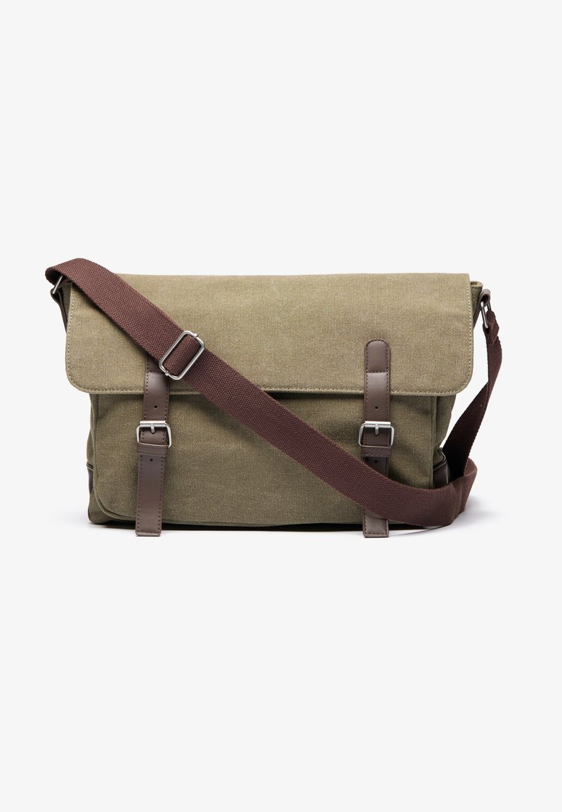 Green canvas messenger bag with brown leather accents, adjustable strap, and silver hardware. Flap closure with buckle details.