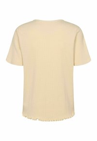Majica kratkih rukava, svijetlo žute boje s rebrastom teksturom i volanima na rubu. Jednostavno okruglo izrezivanje i ležeran kroj.